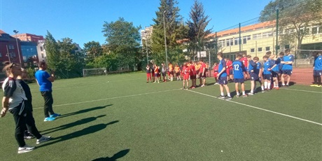 Powiększ grafikę: Drużyny piłki nożnej w strojach sportowych  na boisku przed rozpoczęciem rozgrywek.