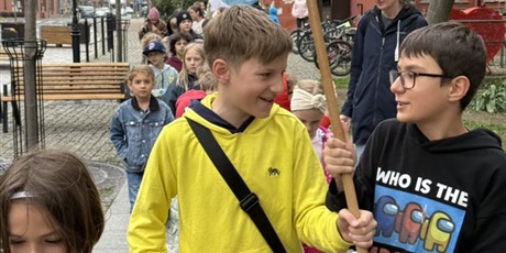 Powiększ grafikę: Uczniowie podczas przemarszu ulicami Gdańska. Trzymają w rękach logo szkoły.