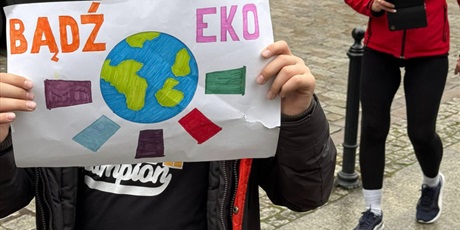 Powiększ grafikę: Uczniowie podczas przemarszu ulicami Gdańska. Trzymają w rękach plakat z ekologicznym hasłem.