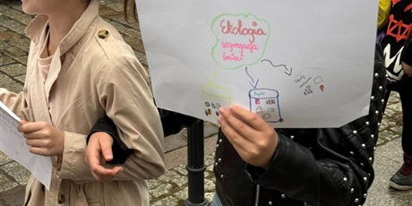 Powiększ grafikę: Uczniowie podczas przemarszu ulicami Gdańska. Trzymają w rękach plakat z ekologicznym hasłem.