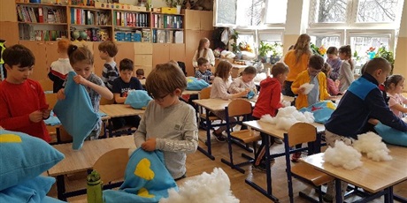Powiększ grafikę: W sali lekcyjnej uczniowie szyją poduszki dla ukraińskich dzieci.