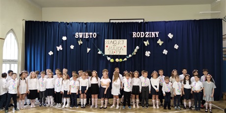 Powiększ grafikę: Dzieci w odświętnych strojach na tle dekoracji podczas występu dla rodziców z okazji Dnia Rodziny