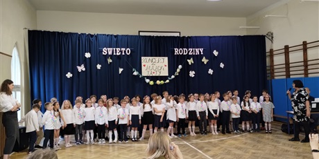 Powiększ grafikę: Dzieci w odświętnych strojach na tle dekoracji podczas występu dla rodziców z okazji Dnia Rodziny