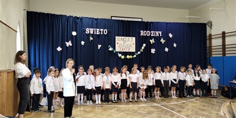 Powiększ grafikę: Dzieci w odświętnych strojach na tle dekoracji podczas występu dla rodziców z okazji Dnia Rodziny