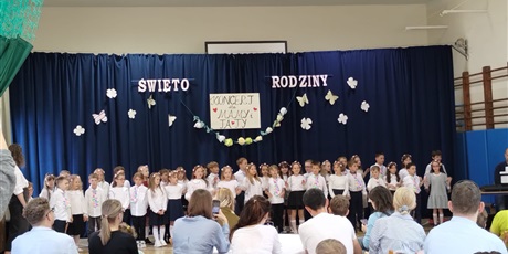 Powiększ grafikę: Dzieci w odświętnych strojach na tle dekoracji podczas występu dla rodziców z okazji Dnia Rodziny