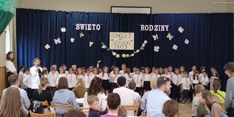 Powiększ grafikę: Dzieci w odświętnych strojach na tle dekoracji podczas występu dla rodziców z okazji Dnia Rodziny