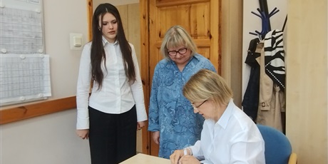 Powiększ grafikę: Odbiór arkuszy egzaminacyjnych w gabinecie dyrektora. W gabinecie dyrektor, nauczycielka i uczennica