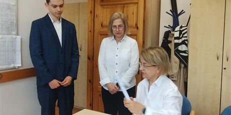 Powiększ grafikę: Odbiór arkuszy egzaminacyjnych w gabinecie dyrektora. W gabinecie dyrektor, nauczycielka i uczeń