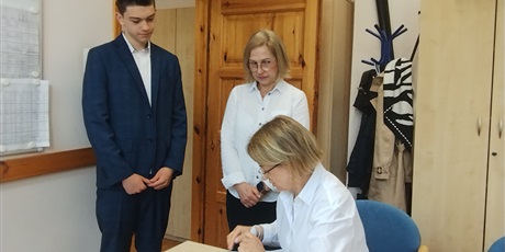 Powiększ grafikę: Odbiór arkuszy egzaminacyjnych w gabinecie dyrektora. W gabinecie dyrektor, nauczycielka i uczeń