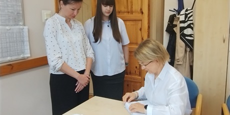 Powiększ grafikę: Odbiór arkuszy egzaminacyjnych w gabinecie dyrektora. W gabinecie dyrektor, nauczycielka i uczennica