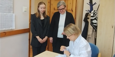 Powiększ grafikę: Odbiór arkuszy egzaminacyjnych w gabinecie dyrektora. W gabinecie dyrektor, nauczycielka i uczennica