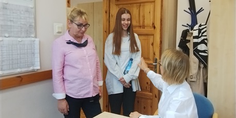Powiększ grafikę: Odbiór arkuszy egzaminacyjnych w gabinecie dyrektora. W gabinecie dyrektor, nauczycielka i uczennica