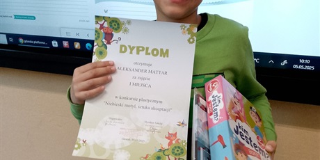 Powiększ grafikę: Chłopiec nagrodzony w konkursie prezentuje swój dyplom