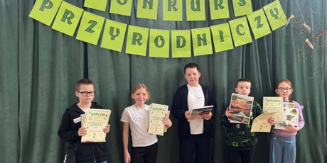 Powiększ grafikę: Laureaci konkursu z nagrodami stoją na tle dekoracji.