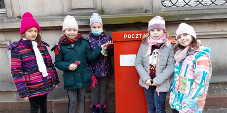 Powiększ grafikę: Pięć dziewczynek stoi przy skrzynce pocztowej przy ulicy Długiej.