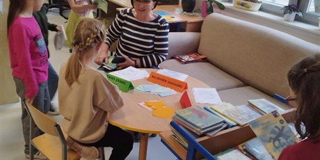 Powiększ grafikę: Uczniowie w bibliotece rozwiązują bajkowe zagadki. 