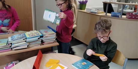Powiększ grafikę: Uczniowie w bibliotece rozwiązują bajkowe zagadki. 