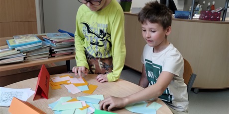 Powiększ grafikę: Uczniowie w bibliotece rozwiązują bajkowe zagadki. 