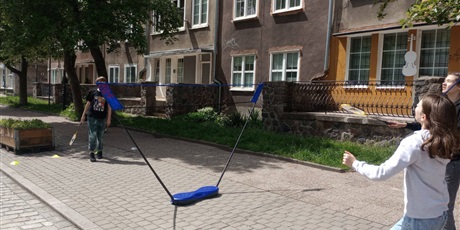 Powiększ grafikę: Dzieci bawiące się piłką przed szkołą.