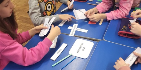 Powiększ grafikę: uczniowie pracują w grupach podczas lekcji, na stoliku pocięte karteczki