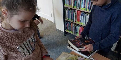 Powiększ grafikę: Dzieci w czytelni WiMBP oglądają książki i czasopisma.