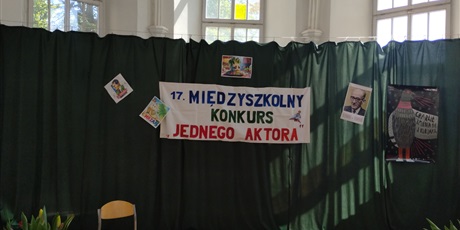 Powiększ grafikę: Dekoracja do XVII Międzyszkolnego konkursu Jednego Aktora. Na zielonym tle baner z nazwą konkursu. Zdjęcie Jana Brzechwy oraz ilustracje do wiersza "Chrzan". Z boku plakat teatru "Miniatura"