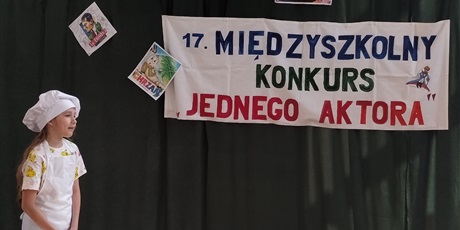 Powiększ grafikę: Dziewczynka w stroju kucharki na tle dekoracji konkursowej