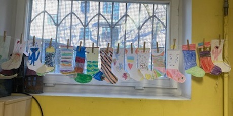 Powiększ grafikę: Na oknie rozwieszone zostały wykonane przez dzieci kolorowe skarpetki.
